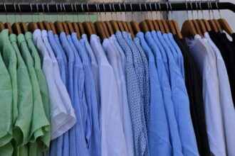 white blue and gray clothes hanging on brown wooden rack