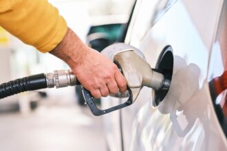 a man pumping gas into his car at a gas station