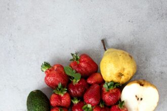 strawberries and bananas on white table